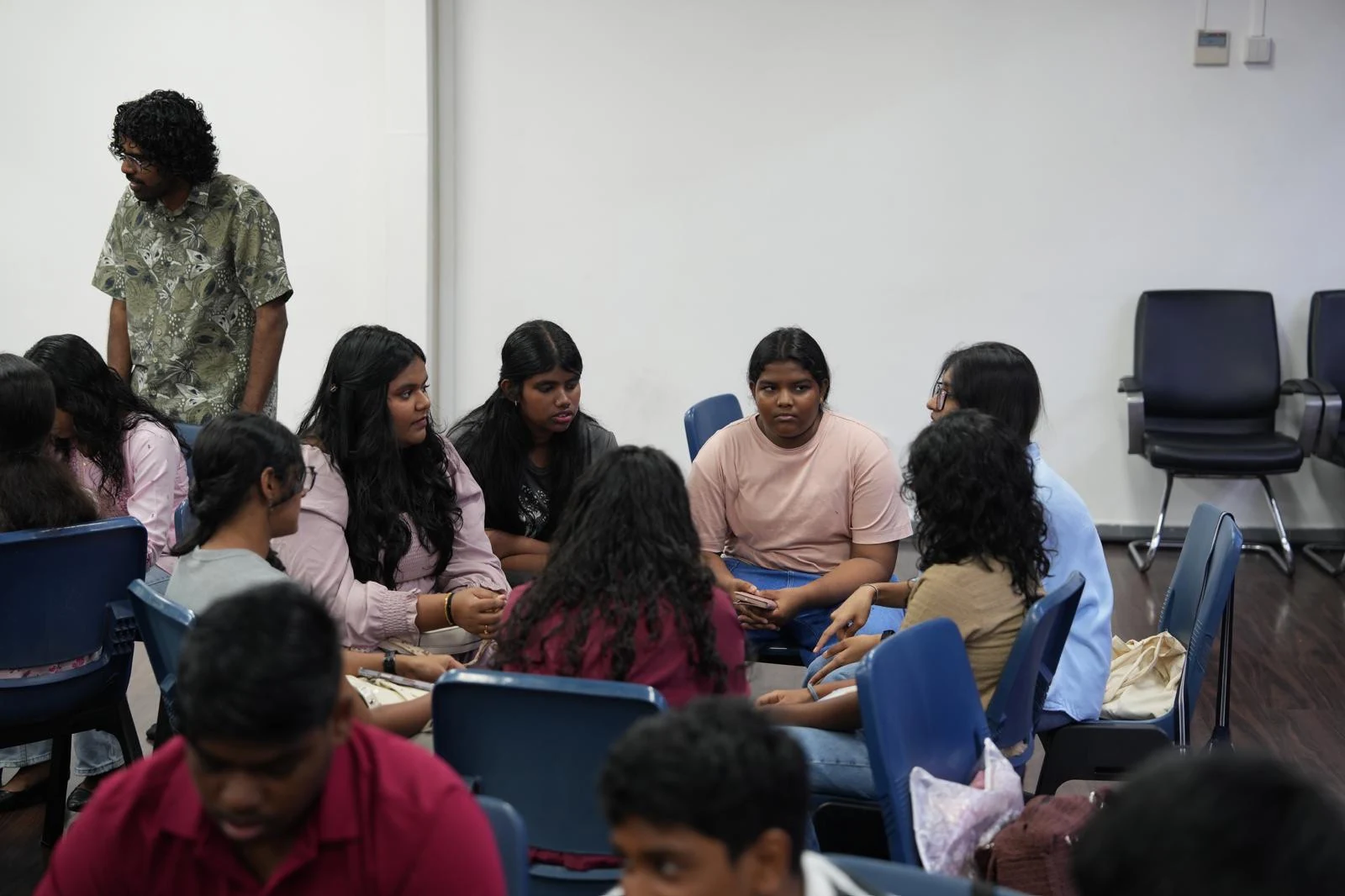 Young people sitting in small circles and talking