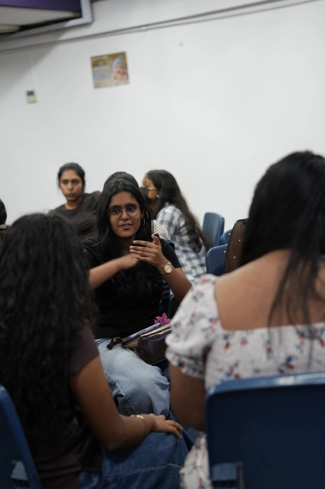 A small group seated together, listening to one another